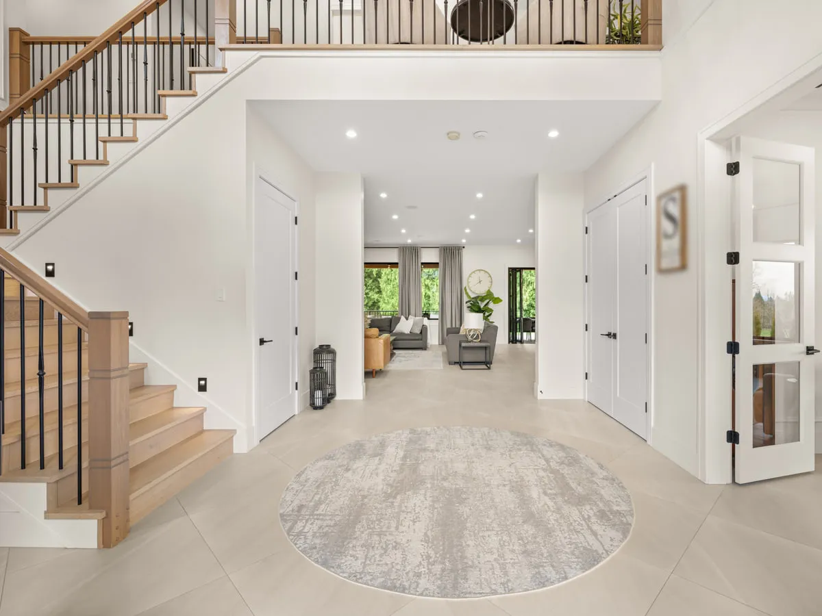 A finished entrance hall with an open stair and a sightline through to the living space.