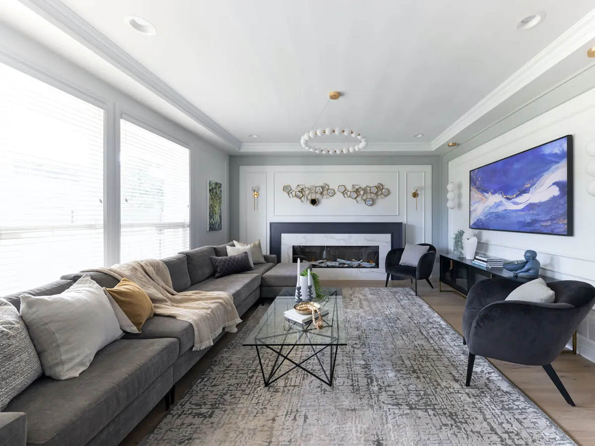 A finished living room with a sectional sofa, a fireplace and a wide window onto the garden.